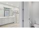 Bright bathroom with white cabinetry, double sinks, glass enclosed shower, and a separate toilet at 1222 Shorecrest Cir, Clermont, FL 34711