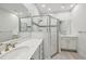 Bright bathroom with white cabinetry, double sinks, and a glass enclosed shower at 1222 Shorecrest Cir, Clermont, FL 34711