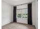 Bedroom with wood-look tile flooring, a window with dark curtains, and a closet at 1222 Shorecrest Cir, Clermont, FL 34711