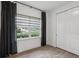 Bedroom with wood-look tile flooring, a window with dark curtains, and a closet at 1222 Shorecrest Cir, Clermont, FL 34711
