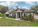 Charming single-story home featuring a stone entryway, well-manicured landscaping, and a two-car garage at 1222 Shorecrest Cir, Clermont, FL 34711