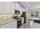 Bright kitchen with stainless steel appliances, granite countertops, custom cabinets, and recessed lighting at 1222 Shorecrest Cir, Clermont, FL 34711