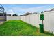 Spacious backyard area featuring green lawn and a pet waste station, enclosed by a pristine white fence for privacy at 131 Sonja Cir # 1, Davenport, FL 33897