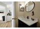 Modern bathroom sink with black fixtures, a round mirror, and decorative accents at 131 Sonja Cir # 1, Davenport, FL 33897