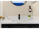 Bathroom sink with black faucet, white countertop, round mirror and hand soap dispenser at 131 Sonja Cir # 1, Davenport, FL 33897