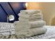 Neatly folded white towels add a touch of luxury to the patterned bedding, complemented by a bedside lamp at 131 Sonja Cir # 1, Davenport, FL 33897