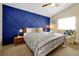 Stylish bedroom with a striking blue accent wall, comfortable bedding, and a cozy seating area near the window at 131 Sonja Cir # 1, Davenport, FL 33897