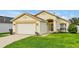 Charming single-story home with a well-manicured lawn, complemented by a two-car garage and yellow trim at 131 Sonja Cir # 1, Davenport, FL 33897