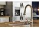 Close-up of a modern kitchen faucet and stainless steel sink, highlighting the granite countertops and appliances at 131 Sonja Cir # 1, Davenport, FL 33897