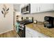 Close-up of modern stainless steel oven, granite countertops, and white cabinetry in the kitchen at 131 Sonja Cir # 1, Davenport, FL 33897