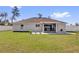 Backyard view featuring a covered patio, a white vinyl fence, and a well-manicured lawn at 15697 Sw 37Th Cir, Ocala, FL 34473