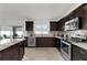 Contemporary kitchen featuring dark wood cabinets, stainless steel appliances, and granite countertops at 15697 Sw 37Th Cir, Ocala, FL 34473