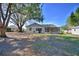 View of the backyard featuring mature trees and the home's exterior with a screened porch at 16 Cedar Dr, Davenport, FL 33837