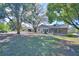 Expansive backyard with mature trees, screened porch and view of the home's exterior at 16 Cedar Dr, Davenport, FL 33837