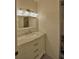 Bathroom vanity featuring a marble countertop, woven mirror, and modern lighting above the sink at 16 Cedar Dr, Davenport, FL 33837