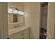 Bathroom vanity with marble countertop, woven mirror, and modern lighting fixtures over the sink at 16 Cedar Dr, Davenport, FL 33837