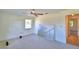 Spacious bedroom featuring neutral carpet, a ceiling fan, and a view of a painting on the floor at 16 Cedar Dr, Davenport, FL 33837