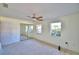 Bedroom with a ceiling fan, carpeted floors, a mirrored closet, and ample natural light at 16 Cedar Dr, Davenport, FL 33837