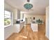 Bright kitchen with a vintage light fixture, center island, hardwood floors, and modern appliances at 16 Cedar Dr, Davenport, FL 33837