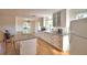 Well-lit kitchen with white cabinets, island seating, and hardwood floors at 16 Cedar Dr, Davenport, FL 33837