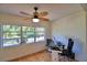 This bright office space features a ceiling fan and a large window overlooking the outdoors at 16 Cedar Dr, Davenport, FL 33837
