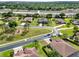 Aerial view of a residential neighborhood showcasing well-manicured lawns, mature trees, and a playground area at 16548 Caravaggio Loop, Montverde, FL 34756