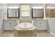 Bathroom featuring a central soaking tub, dual vanities, and tiled flooring at 16548 Caravaggio Loop, Montverde, FL 34756
