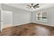 Bedroom showcasing dark laminate wood flooring, a ceiling fan, and a bright, windowed view at 16548 Caravaggio Loop, Montverde, FL 34756