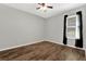 Bedroom with dark laminate wood flooring, a ceiling fan, and a window with black curtains at 16548 Caravaggio Loop, Montverde, FL 34756