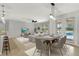 Open dining area with a glass table, modern lighting, and a view of the backyard pool at 16548 Caravaggio Loop, Montverde, FL 34756