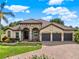 Beautiful home featuring a three-car garage, stone accents, and a well-manicured lawn and landscape at 16548 Caravaggio Loop, Montverde, FL 34756
