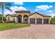 Beautiful home featuring a three-car garage, stone accents, and a well-manicured lawn and landscape at 16548 Caravaggio Loop, Montverde, FL 34756