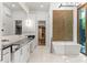 Luxury bathroom featuring a freestanding tub, double vanity, modern fixtures and textured accent wall at 1660 Palmer Ave, Winter Park, FL 32789