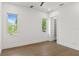 Minimalist bedroom with hardwood floors, two windows with tree views, and a closet at 1660 Palmer Ave, Winter Park, FL 32789