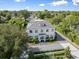 Aerial view of a beautiful two-story home with lush landscaping, a paver driveway, and a manicured lawn at 1660 Palmer Ave, Winter Park, FL 32789