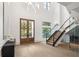 A grand foyer with a staircase, a modern chandelier, and beautiful wood and glass doors at 1660 Palmer Ave, Winter Park, FL 32789