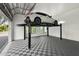 Spacious garage outfitted with car lift and diamond patterned tiling at 1660 Palmer Ave, Winter Park, FL 32789