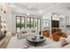 Open concept living area with modern lighting, white sofa, and views to the outdoor living space at 1660 Palmer Ave, Winter Park, FL 32789
