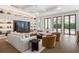 An elegant living room with a built-in entertainment center, plush sofas, and access to the pool at 1660 Palmer Ave, Winter Park, FL 32789