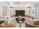 Bright living room features custom built-ins and shelving, with cozy seating around a round coffee table at 1660 Palmer Ave, Winter Park, FL 32789