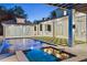 A dazzling backyard pool and jacuzzi are surrounded by a patio and luscious landscaping at 1660 Palmer Ave, Winter Park, FL 32789