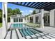 Backyard pool and spa are surrounded by beautiful landscaping and a pergola covered lounge area at 1660 Palmer Ave, Winter Park, FL 32789
