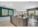 Modern kitchen with a large island, stainless steel appliances, and cabinets with an open view to the dining area at 1736 Three Bars Rd, Kissimmee, FL 34744