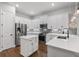 Well-equipped kitchen with white cabinets, a center island, stainless steel appliances, and modern fixtures at 1763 White Feather Loop, Oakland, FL 34787