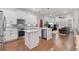 Open-concept kitchen leading into the living room, featuring white cabinetry and stainless steel appliances at 1763 White Feather Loop, Oakland, FL 34787
