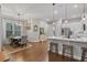 Bright kitchen features an island with bar seating, pendant lights, hardwood floors, and a dining area at 1763 White Feather Loop, Oakland, FL 34787