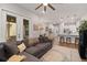 Cozy living room showcases a gray sofa, hardwood floors, and an open floor plan to the kitchen at 1763 White Feather Loop, Oakland, FL 34787