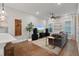 Spacious living room with a ceiling fan, large windows, hardwood floors, and a comfortable gray sofa at 1763 White Feather Loop, Oakland, FL 34787