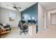 This home office features a dark accent wall, a desk, and a ceiling fan at 1763 White Feather Loop, Oakland, FL 34787