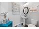 Charming powder room features a pedestal sink, decorative mirror, and modern fixtures at 1763 White Feather Loop, Oakland, FL 34787